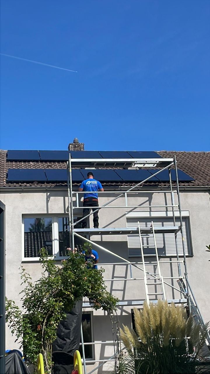 Monteur auf dem Gerüst bei der Montage von Solarmodulen
