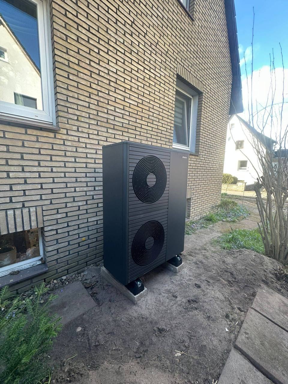 Wärmepumpe vor einer Klinkerfassade